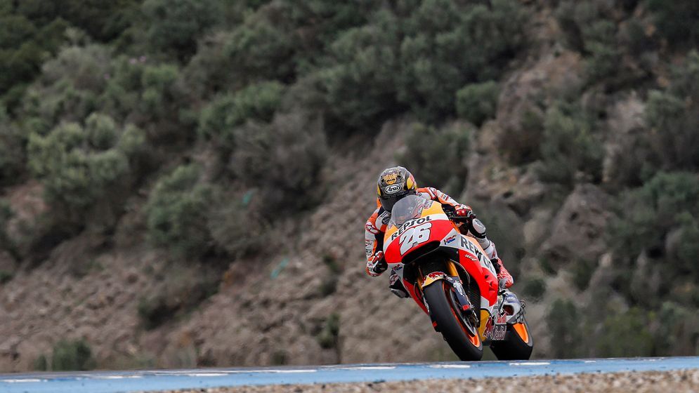 Dani Pedrosa rodando en pista frente unos arbustos de secano