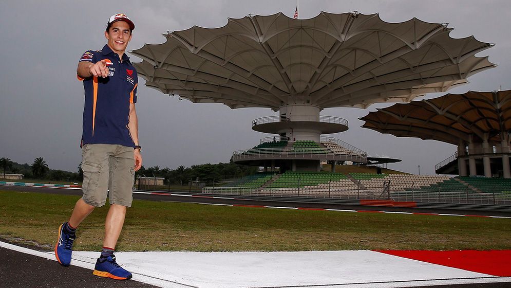 Marc Márquez andando en el circuito frente a las gradas con forma de flor