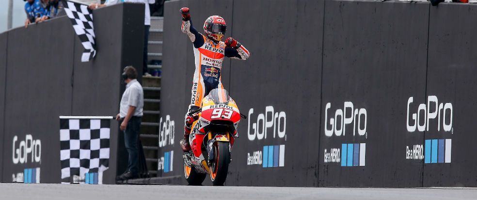 Marc Márquez celebrando la victoria de pie sobre la moto