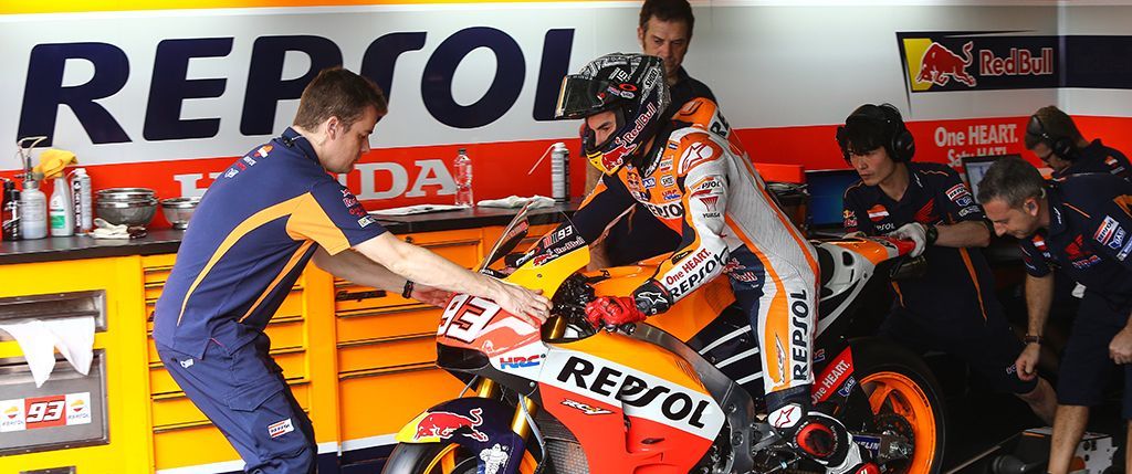 Marc con sus técnicos en el box, montado sobre la moto