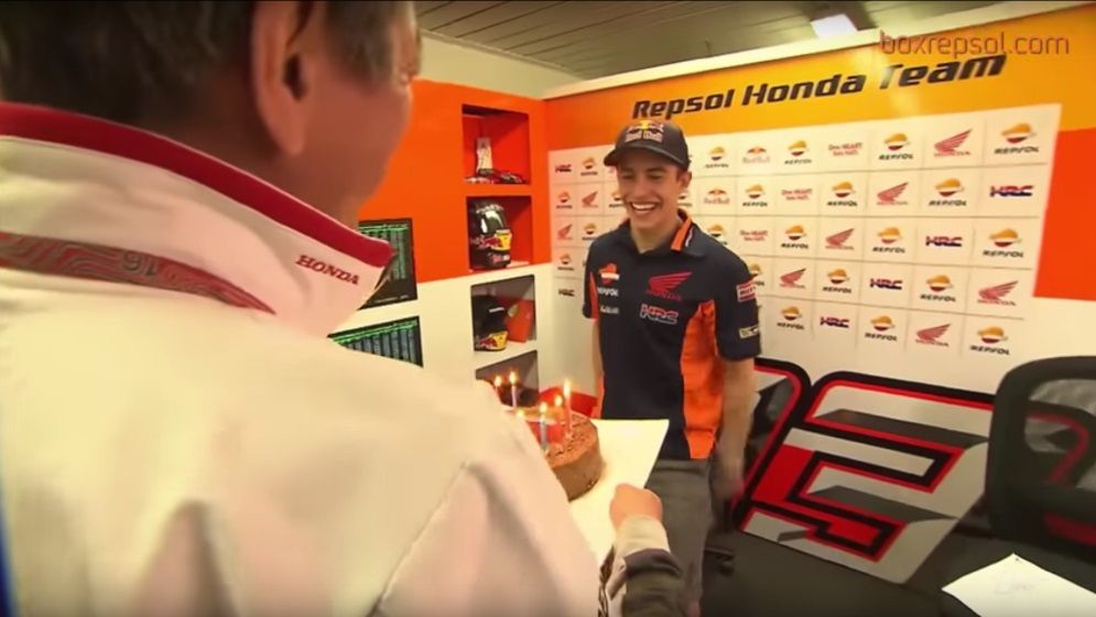 Marc Márquez en el box frente a una tarta